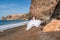 Woman beach white dress flying on Wind. Summer Vacation. A happy woman takes vacation photos to send to friends.