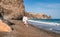 Woman beach white dress flying on Wind. Summer Vacation. A happy woman takes vacation photos to send to friends.