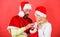 Woman and bearded man in santa hat expecting gift red background. Check contents of christmas stocking gift received