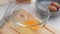 Woman beating eggs in a glass bowl. Young woman cooking in the kitchen.