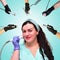A woman beautician against the background of a collage of handpieces for carrying out hardware slimming procedures in a spa salon.