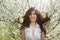 Woman with beautiful hair in the lush spring garden smiling and rejoicing, beauty, makeup, hair
