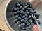 A Woman beautiful hand holding fresh blueberry fork Healthy fruit in a stainless steel bowl