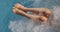 Woman with beautiful legs in the pool with whirlpool of luxuriou