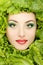 Woman beauty face with green fresh lettuce leaves