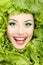 Woman beauty face with green fresh lettuce leaves