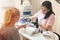 Woman in beauty salon. Cosmetologist shows color palette of manicure with gel lacquer, samples. Beauty and self care theme