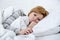 woman in bed with thermometer feverish weak suffering winter cold flu virus