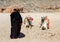 Woman Bedouin in black clothes against the background of lying camels.