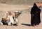 Woman Bedouin in black clothes and camel, Egypt.