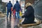 Woman beggar with walking stick asking for money on Moscow street in winter