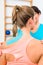 Woman from behind with Kinesio tape on shoulder in physiotherapy