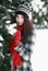 Woman behind snow covered pine tree