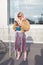 Woman with beige fur coat, blue velvet Gucci pouch and striped metallic skirt before Gucci fashion show,