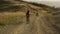 Woman on bicycle looking back at man. Bicyclists exercising in landscape