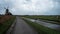 Woman on bicycle next to windmill