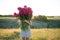 Woman with big bouquet of rose peonies at sunset