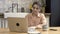 Woman with a big cup and her notebook in the kitchen of her modern apartment. Stock footage. Serious young female