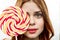 woman with big multicolored round face lollipop sweet candy close-up