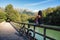 Woman with bike in Bridge in Reservoir of Valdemurio, Senda del Oso, Asturias, Spain