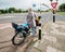 Woman on bike waiting to cross the highway