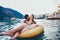 Woman in bikini floating on inflatable ring and her boyfriend in sea