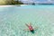 Woman in bikini floats on the turquoise, tropical sea of the Maldives