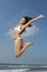 Woman In Bikini Jumping Midair On Beach