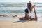 Woman in bikini practice yoga Eka Pada Rajakapotasana Royal pigeon Pose at seaside, close-up view