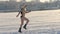 A woman in a bikini runs on a frozen river.