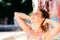 Woman in bikini at the splashing fountain. Summer heat.