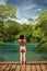 Woman with bikini stands,and take picture of waterfall in Bonito