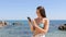 Woman in bikini taking selfie on the beach