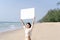 Woman in bikinis holding blank white board on the beach