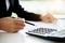 Woman with bills and calculator. Woman using calculator to calculate bills at the table in office. Calculation of costs.