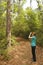 Woman with Binoculars Birdwatching on a Forest Trail