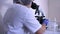 Woman biologist in the laboratory works with a microscope