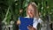 Woman biology scientist agronomist checking cucumber fertilize analyzing growth condition greenhouse