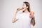 Woman biting hamburger on gray background