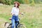 Woman with a black bicycle in a summer park