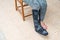 woman with black cast on leg sitting on wood chair, body injury