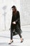 Woman in black clothing and Louboutin shoes before Simonetta Ravizza fashion show, Milan Fashion Week Day 1