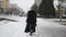 Woman in black coat walking on street