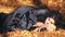 Woman In Black Cuddling A Furtail Lying In Autumn