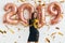 Woman in black dress and yellow crown celebrating new year, having fun