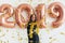 Woman in black dress and yellow crown celebrating new year, having fun