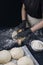 Woman in black gloves rolling out yeast dough with a rolling pin. Process of making bakery. Adjarian Khachapuri Recipe â€“