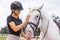 Woman with a black helmet stroking a chestnut horse head, close up shot