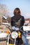 Woman in black leather jacket turn back upon while sitting on motorcycle