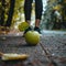 Woman in black leggings with green apple on footpath in autumn forest. Healthy lifestyle concept